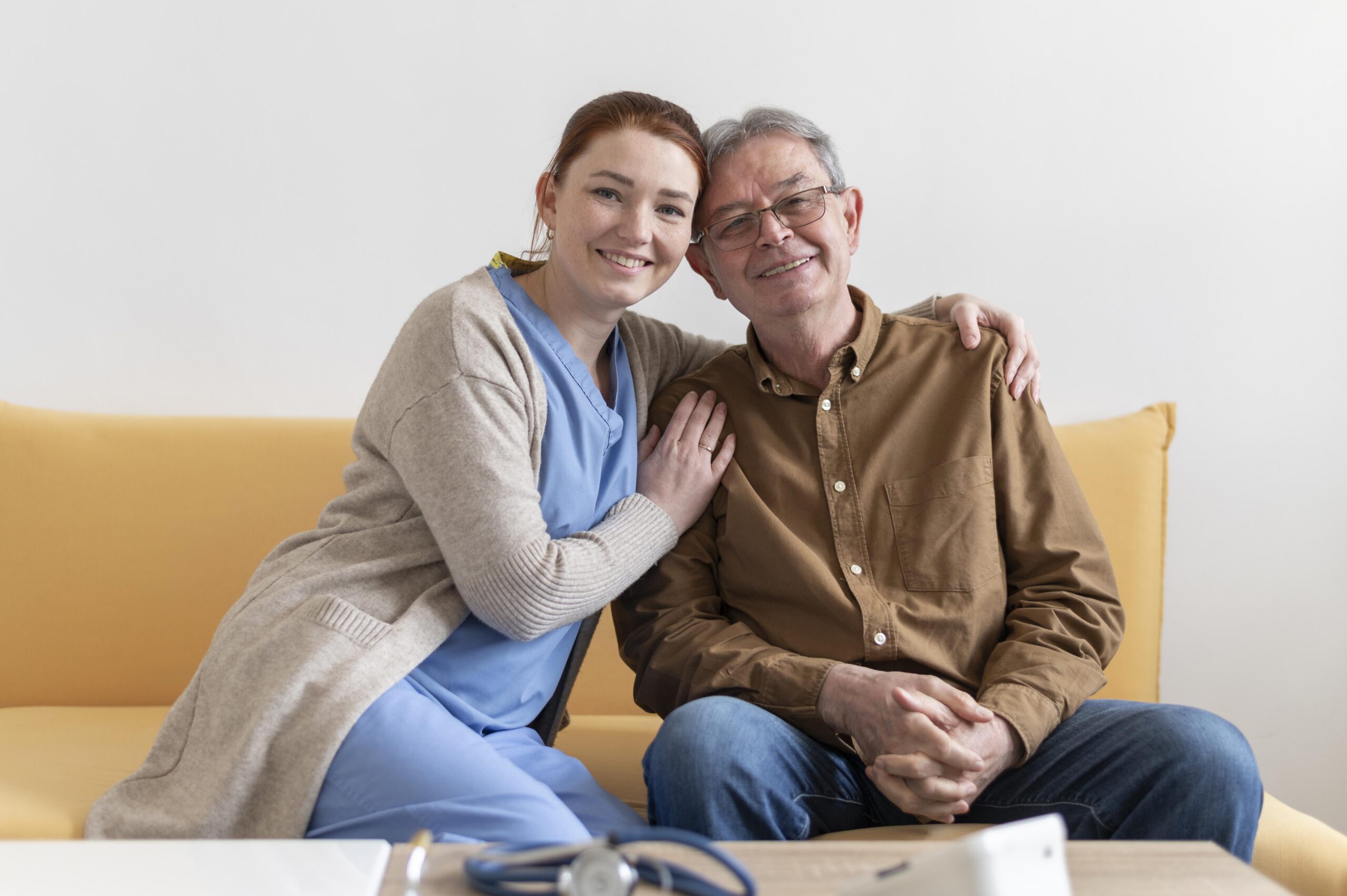 Professional caregiver supporting an elderly man in a comfortable home setting